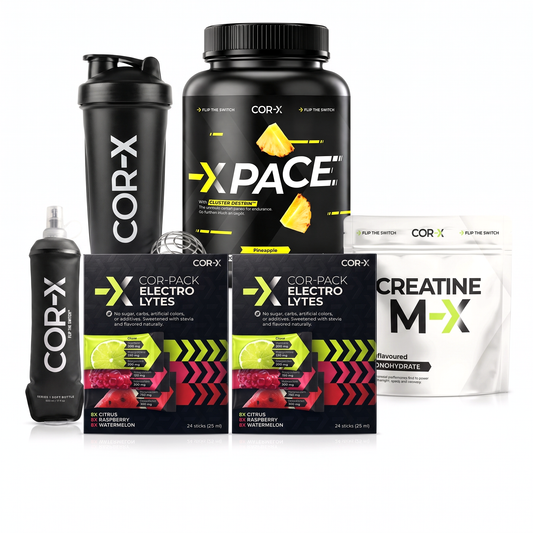 Kompletný systém COR-X: dve balenia X-Electrolytes, X-PACE, Creatine M-X, šejker a soft flask na bielom pozadí